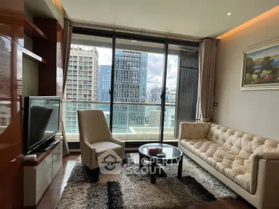 Luxurious living room with city view, elegant furniture, and large windows in a high-rise apartment.