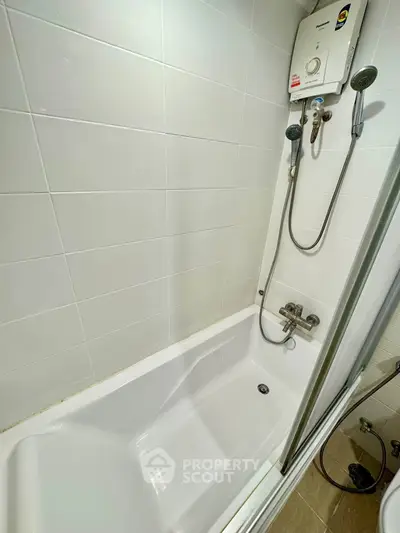 Modern bathroom with bathtub and shower in a sleek tiled setting.