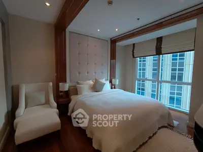 Luxurious bedroom with elegant decor and large window offering city views