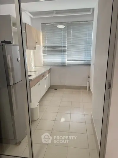 Compact kitchen with modern appliances and natural light