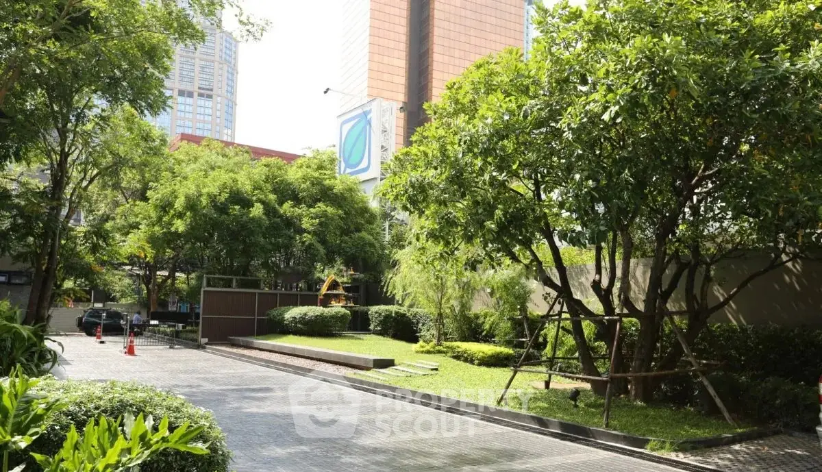 Lush green garden area with paved pathway in modern urban setting