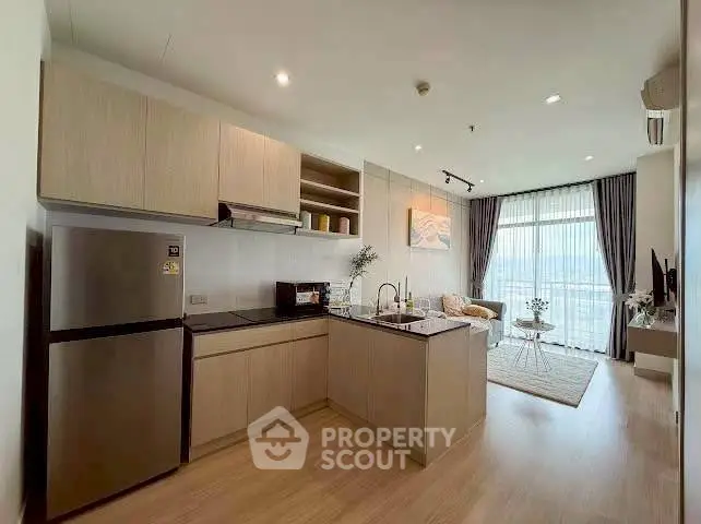 Modern open-layout kitchen and living room with natural light and stylish decor.