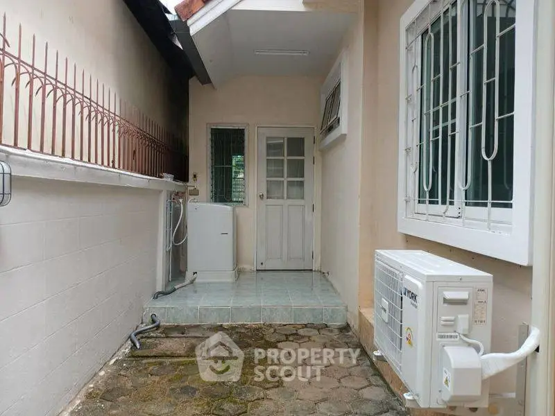 Charming exterior view of a cozy home with air conditioning unit and laundry area.