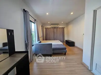 Spacious bedroom with modern decor and large windows for natural light