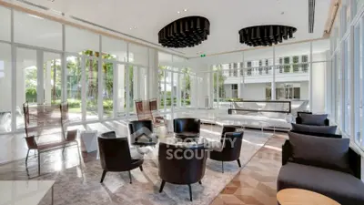 Luxurious modern living room with elegant black chairs and large windows offering garden views.