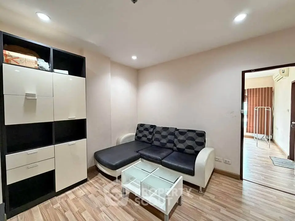 Modern living room with stylish black and white furniture and wooden flooring