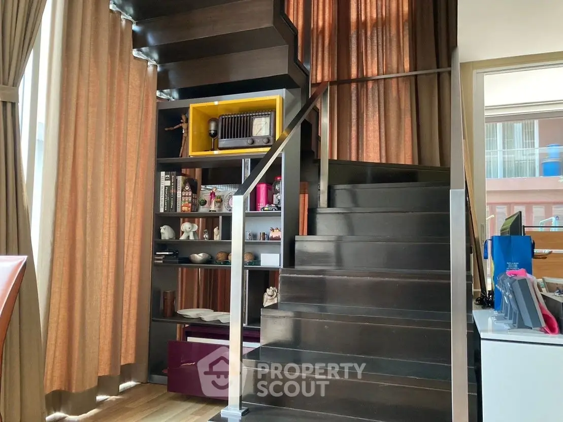 Modern interior with stylish staircase and built-in shelving, perfect for urban living.