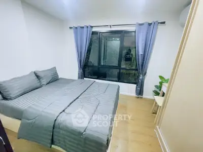 Cozy bedroom with modern decor and large window for natural light