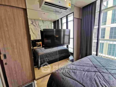 Modern bedroom with mirrored wardrobe and balcony view in luxury apartment