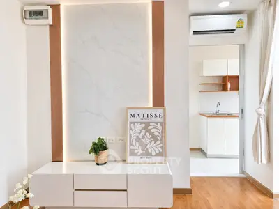 Modern living room with stylish decor and open kitchen layout, featuring elegant lighting and wooden flooring.