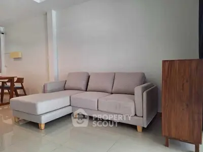 Modern living room with stylish gray sectional sofa and wooden accents