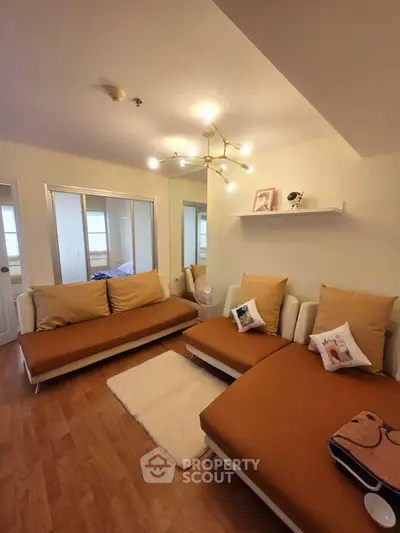 Cozy living room with modern lighting and stylish brown sofas, perfect for relaxation and entertaining guests.