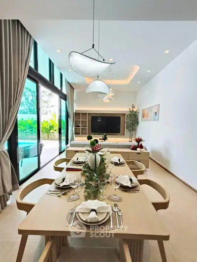 Luxurious modern living room with elegant dining area and large windows overlooking lush greenery.