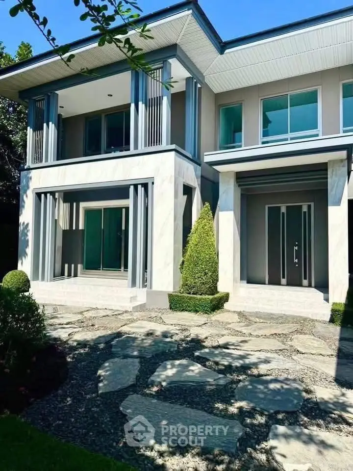 Stunning modern two-story house with elegant facade and lush landscaping.