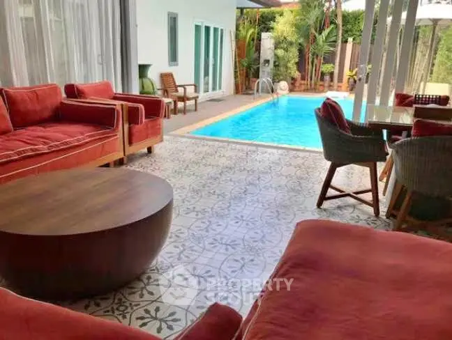 Luxurious poolside patio with stylish seating and lush greenery, perfect for relaxation and entertaining.
