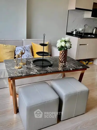Modern living room with elegant marble coffee table and stylish kitchen in open layout.