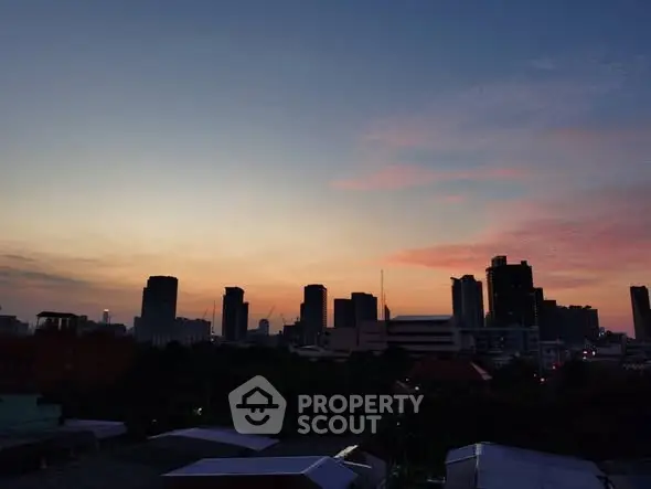 Stunning city skyline view at sunset with silhouetted skyscrapers and colorful sky.