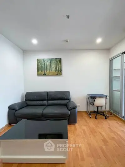 Modern living room with sleek black leather sofa and glass coffee table, perfect for urban living.
