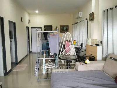 Spacious living room with modern decor and natural light, featuring a cozy seating area and stylish furnishings.