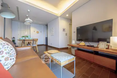 Spacious modern living room with stylish decor and large TV, perfect for relaxation and entertainment.