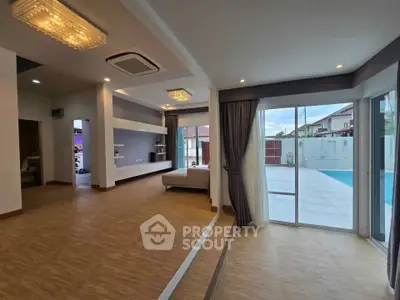Spacious modern living room with pool view and elegant lighting