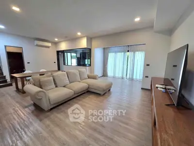 Spacious modern living room with elegant sofa and large windows for natural light.