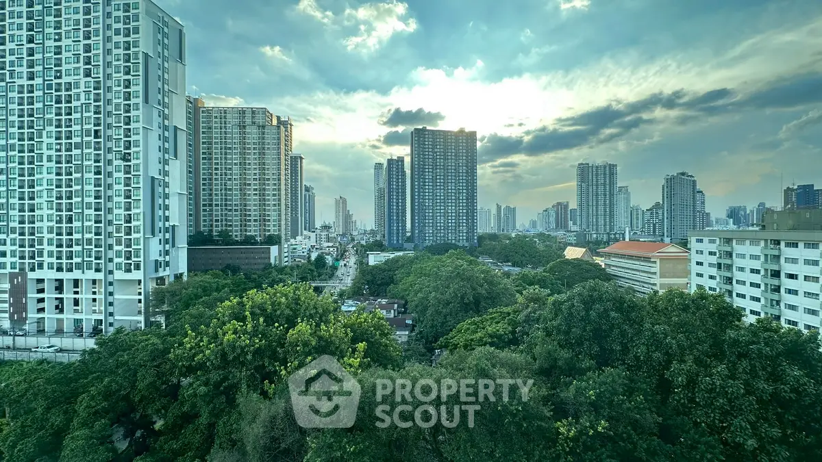 Stunning cityscape view with lush greenery and towering skyscrapers under a dramatic sky.