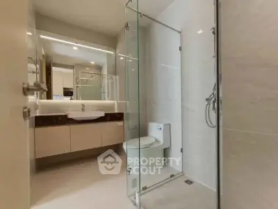 Modern bathroom with glass shower and sleek fixtures in a contemporary apartment.
