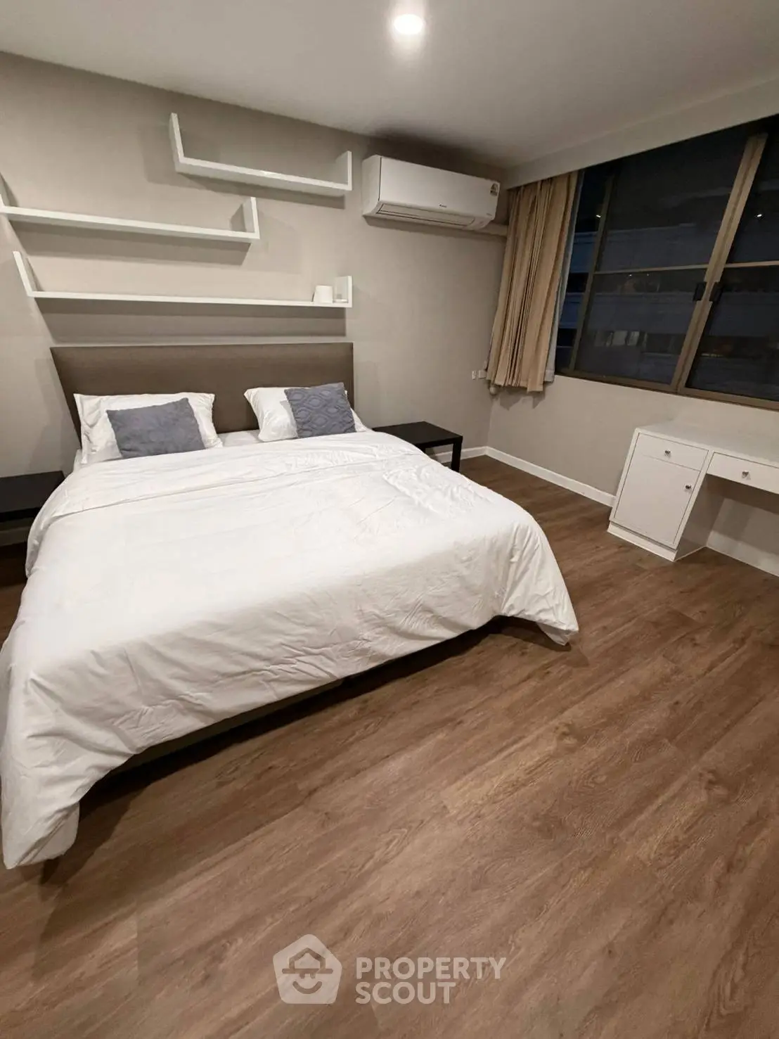 Spacious modern bedroom with elegant decor and large window view