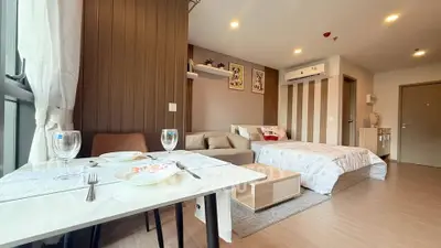 Modern studio apartment with cozy living area and dining space, featuring stylish decor and ample natural light.