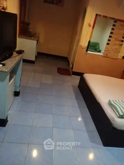 Cozy bedroom with tiled flooring and modern amenities, perfect for comfortable living.