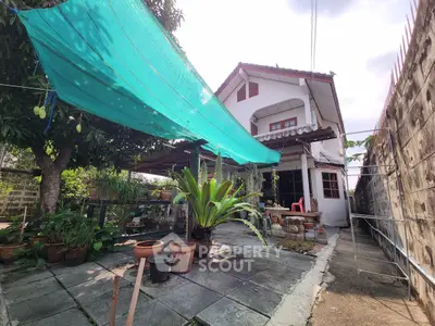 Charming two-story house with spacious patio and lush garden, perfect for outdoor relaxation and entertaining.