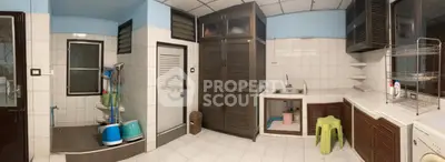 Spacious kitchen with ample storage and tiled flooring, featuring a sink and open shelving.