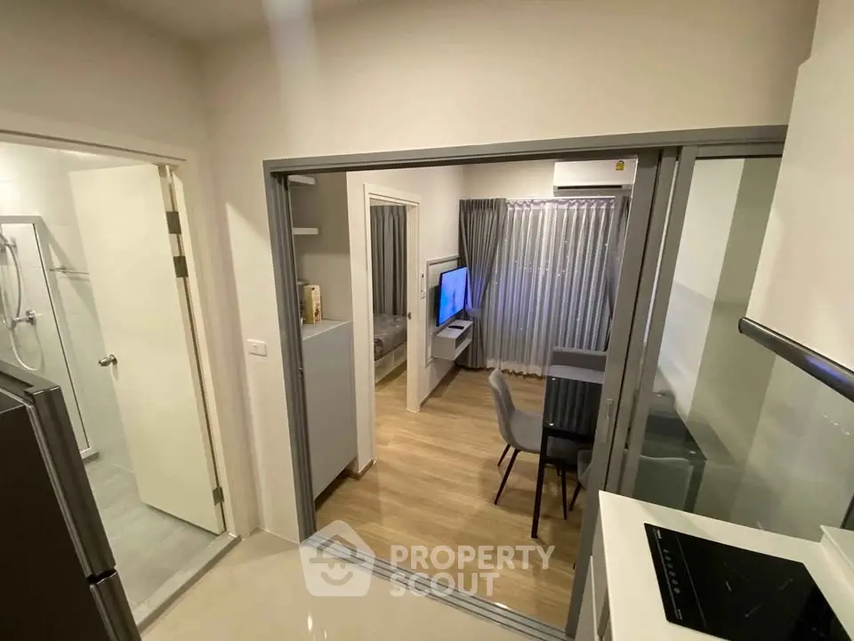 Modern apartment interior with open layout, featuring a cozy living area and sleek kitchen design.