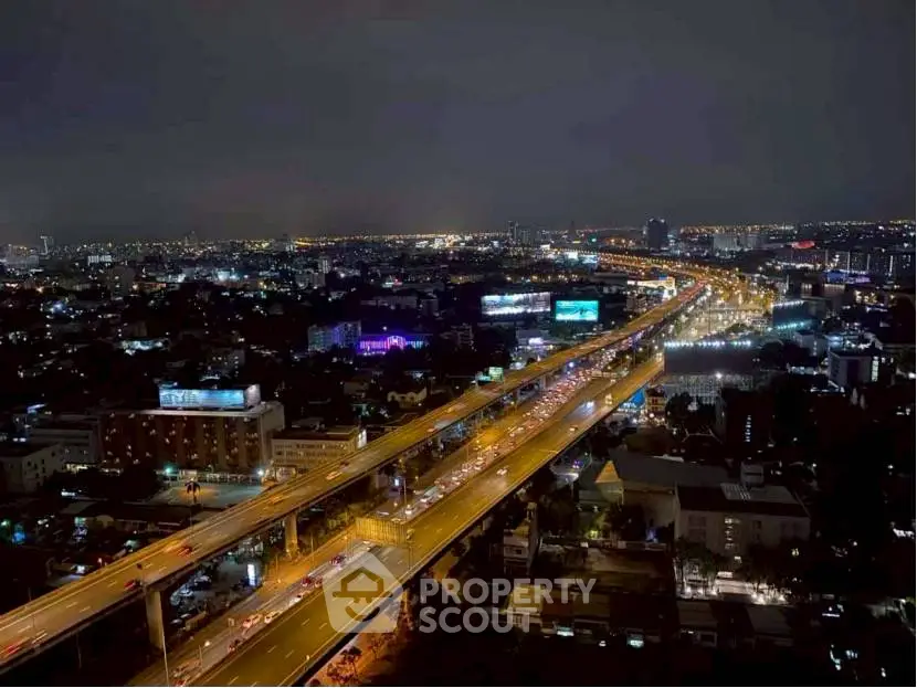 Stunning cityscape night view from high-rise building showcasing vibrant city lights and bustling roads.