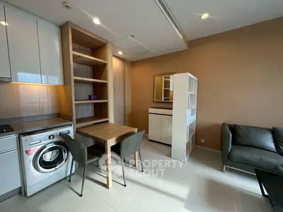 Modern apartment interior with washing machine and cozy seating area