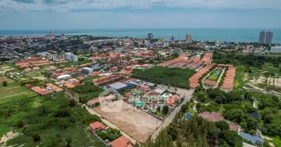 Aerial view of a coastal city with residential and commercial buildings, showcasing proximity to the ocean.
