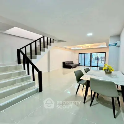 Spacious modern living room with sleek staircase and dining area