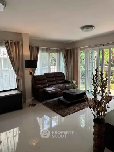 Spacious living room with modern decor and large windows for natural light.