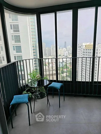 Stunning high-rise balcony with panoramic city views and modern seating area.