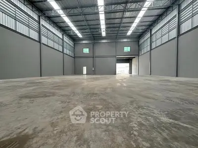 Spacious industrial warehouse with high ceilings and ample natural light.