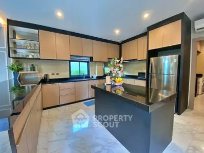 Modern kitchen with sleek cabinetry and island, featuring stainless steel appliances and elegant lighting.