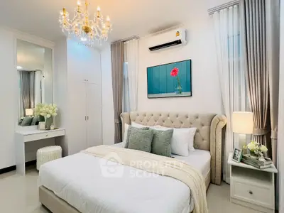 Luxurious bedroom with elegant chandelier and plush bedding in modern apartment.