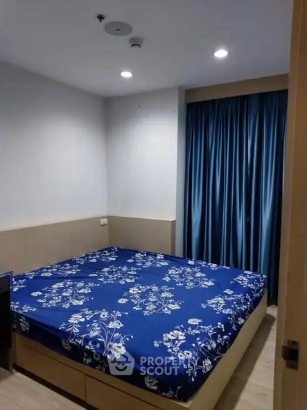 Cozy bedroom with blue floral bedding and elegant curtains