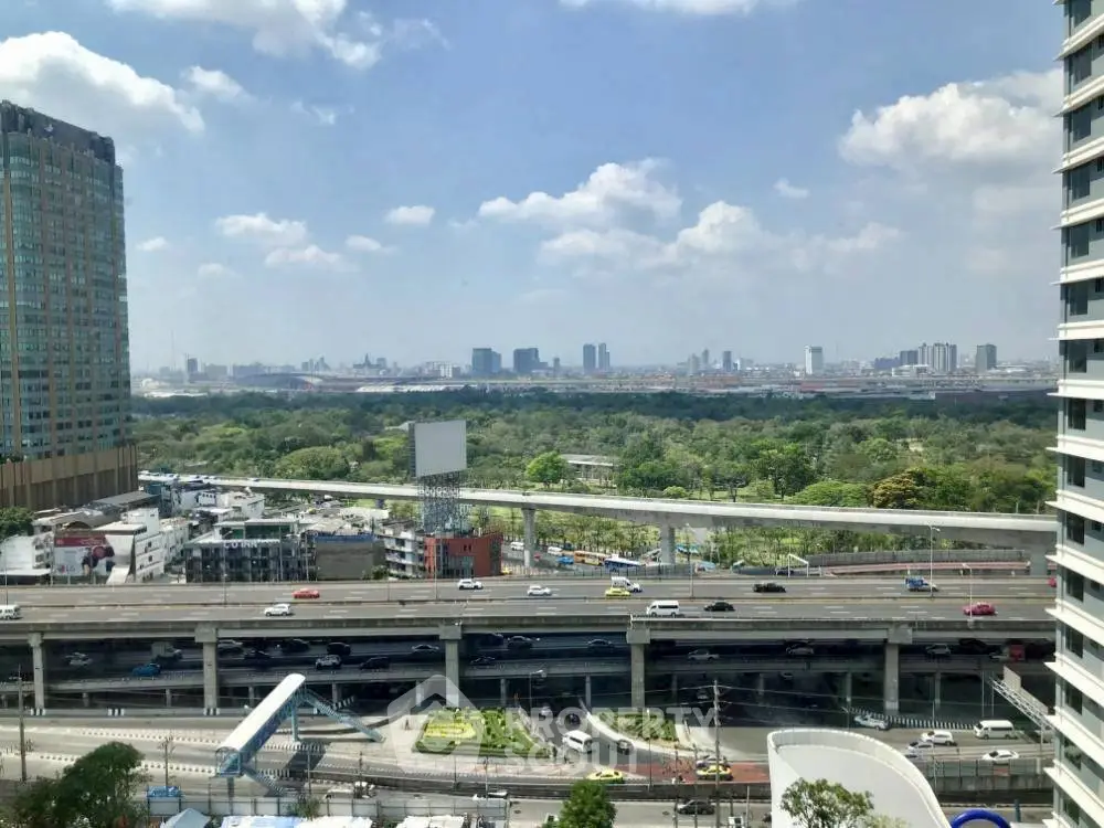 Stunning cityscape view from high-rise building with lush greenery and urban skyline.