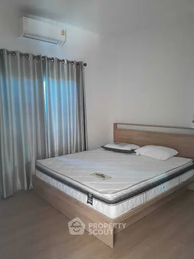 Modern bedroom with wooden bed frame and air conditioning