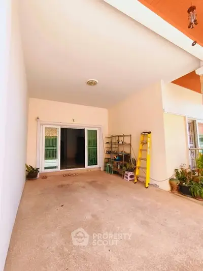 Spacious covered patio with sliding glass doors and garden accents
