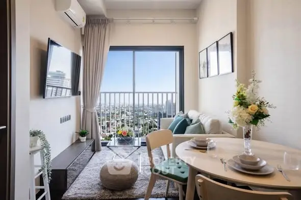 Modern living room with city view, stylish decor, and cozy dining area in a high-rise apartment.