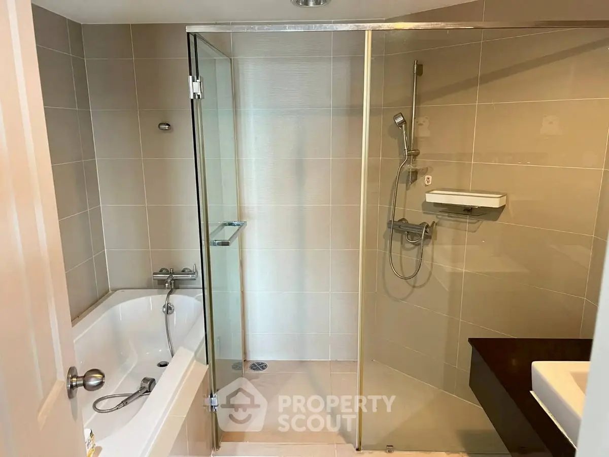 Modern bathroom with glass shower and bathtub in sleek design