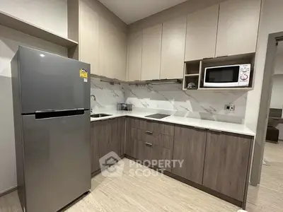 Modern kitchen with sleek cabinetry and stainless steel appliances in a stylish apartment.
